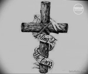 Фото тату эскиз деревянного креста с надписью 'Cling To The Cross'. Черно-белый рисунок, выполненный в реалистичной технике.