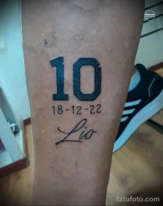 Фото минималистичной татуировки с номером "10" и именем "Leo", выполненной черными чернилами на коже.