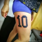 Фото тату на бедре с изображением цифры '10' в черном цвете. Минималистичный и стильный дизайн.