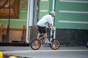 Фотография BMX-райдера в движении с видимой татуировкой на руке, демонстрирующая энергию и свободу уличной культуры.