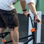 Крупный план руки BMX-райдера с детально проработанной татуировкой, демонстрирующей яркие цвета и сложный рисунок.