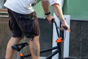 Крупный план руки BMX-райдера с детально проработанной татуировкой, демонстрирующей яркие цвета и сложный рисунок.