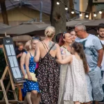 Фото тату голубой розы на спине женщины, вид сбоку, уличная фотография, естественное освещение, детализированный рисунок.