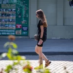 Фото тату на голени, изображающее реалистичные цветы и летящую бабочку. Черно-серые тона, детализированная проработка.