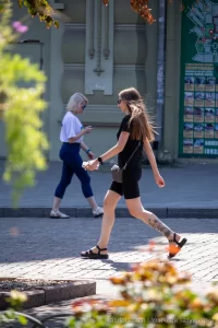 Фото тату на ноге с изображением полевых цветов и бабочки. Татуировка выполнена в реалистичном стиле.