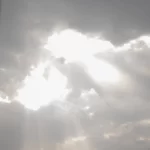 Фотография драматичного неба с темными облаками и пробивающимися сквозь них солнечными лучами. Атмосферный снимок, передающий ощущение силы и величия природы.