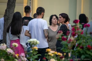 Фото тату на руке мужчины, идущего по улице. Рисунок татуировки выполнен в темных тонах, изображает абстрактный узор. Идеально для поиска идей для тату.