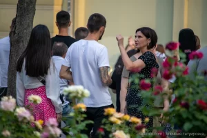 Фото тату на руке мужчины, идущего по улице. Рисунок татуировки выполнен в темных тонах, изображает абстрактный узор. Идеально для поиска идей для тату.