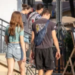 Фото тату на шее мужчины: темный геометрический узор, выполненный в стиле трайбл. Видна часть татуировки на плече и руке.