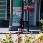 Фото тату на ногах мужчины, идущего по улице. Видны детализированные рисунки на голенях и бедрах, выполненные в реалистичном стиле.