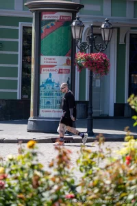 Фото тату на ногах мужчины, идущего по улице. Видны детализированные рисунки на голенях и бедрах, выполненные в реалистичном стиле.