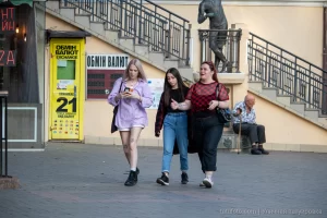Фото тату на ноге девушки: небольшой рисунок, расположенный на внешней стороне бедра. Современный уличный стиль, яркая одежда.
