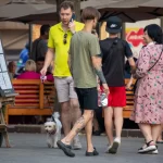 Фото тату на руке мужчины: реалистичный рисунок с изображением черепа и цветов в темных тонах. Идеи для татуировок в стиле реализм.