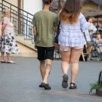 Фотография мужчины с татуировками на руке и голени. Видны детали рисунков, выполненных в черном цвете.
