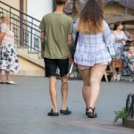 Фотография мужчины с татуировками на руке и голени. Видны детали рисунков, выполненных в черном цвете.