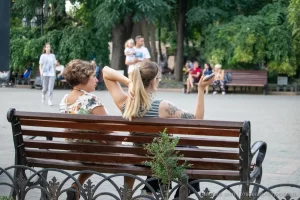 Фото тату: черно-серая татуировка с изображением цветов и птиц на руке девушки. Детализированный рисунок с элементами ботанической иллюстрации.