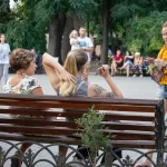 Фото тату: крупный план черно-серой татуировки с цветами и птицами на руке. Детализированный рисунок с акцентом на текстуру перьев и лепестков.