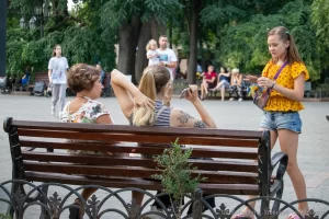 Фото тату: крупный план черно-серой татуировки с цветами и птицами на руке. Детализированный рисунок с акцентом на текстуру перьев и лепестков.