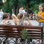 Фото тату: черно-серая татуировка с изображением цветов и птиц на руке девушки. Детализированный рисунок с элементами ботанической иллюстрации.