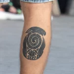 Татуировка со спиралью и узорами внизу правой ноги парня 3
