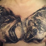 Фото татуировки с двумя головами медведей, выполненной в технике blackwork с использованием точечной штриховки и звездными узорами на груди.
