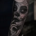Фото тату: реалистичная татуировка сахарной черепушки (Calavera) на руке, с детальной проработкой и выразительным взглядом.