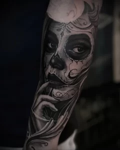 Фото тату: реалистичная татуировка сахарной черепушки (Calavera) на руке, с детальной проработкой и выразительным взглядом.