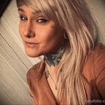 Фото тату бабочки и надписи на шее девушки. Цветная татуировка, выполненная в акварельном стиле, с яркими красками и плавными переходами.
