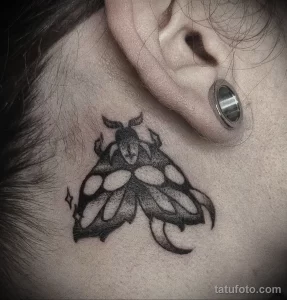Фото татуировки на шее: изображение жука-носорога в стиле blackwork. Детализированный рисунок с использованием черных тонов.