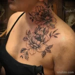 Фото тату: изящные пионы, выполненные в технике blackwork, украшают грудь и шею женщины. Детализированные лепестки и листья.