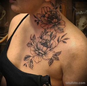 Фото тату: изящные пионы, выполненные в технике blackwork, украшают грудь и шею женщины. Детализированные лепестки и листья.