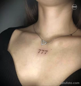 Фото тату с изображением сердца и числа "777" на женской ключице. Черно-белая татуировка, минималистичный дизайн, тонкие линии.