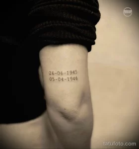 Фото тату с датами "26-06-1945" и "05-04-1946" на женской руке. Минималистичный дизайн, черные чернила, четкие линии.