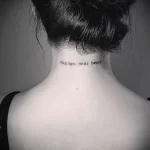 Фото татуировки надписи 'courage, dear heart' на затылке девушки. Черный цвет, минималистичный шрифт, вдохновляющая фраза, идеи для тату.