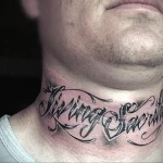 Фотография татуировки на шее мужчины с надписью «Living Sacrifice» черными чернилами. Текст выполнен каллиграфическим шрифтом с декоративными элементами.