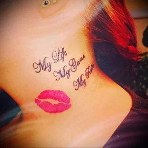 Фото тату на шее девушки с изображением розовых губ и надписью "My Life My Game My Rules". Смелый и вдохновляющий рисунок.