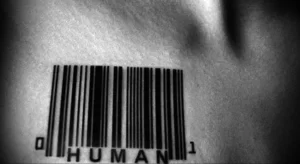 Фото тату штрихкода с надписью 'HUMAN' на шее. Черно-белый рисунок татуировки, символизирующий идентификацию человека.