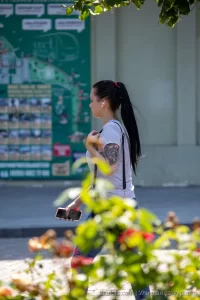 Фото татуировки на руке девушки, выполненной в темных тонах. Виден рисунок, напоминающий птицу или цветок. Идеальный эскиз тату для нежных и романтичных натур.