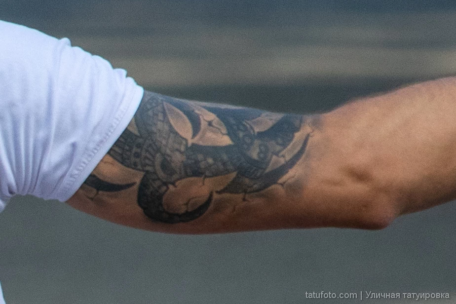 Фрагмент татуировки с цифрами и узором на правой руке мужчины 5