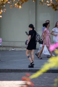 Фото тату на ноге девушки, изображающее черную кошку, цифры '199' и другие элементы. Татуировка выполнена в черном цвете и выглядит очень стильно.