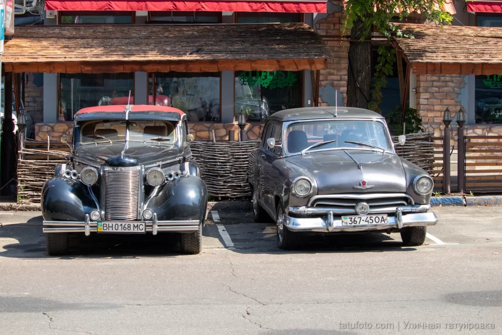 две старинные ретро-машины припаркованные у ресторана 2