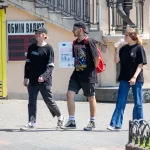 Фото татуировки на шее: портрет мужчины с кепкой и надписью. Черно-белая татуировка, детализированная проработка.