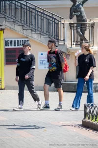 Фото татуировки на шее: портрет мужчины с кепкой и надписью. Черно-белая татуировка, детализированная проработка.