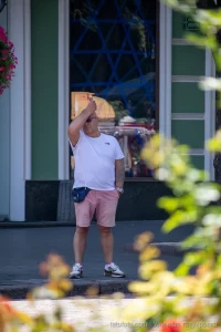 Фото татуировки на плече: изображение японского дракона, обвивающегося вокруг ветви с цветами. Яркие цвета, детализированная проработка.