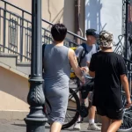 Фото тату на руке женщины: портрет мужчины с усами и пером индейца, выполненный в черно-серых тонах. Видна часть одежды и лица другого человека.