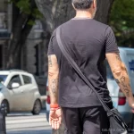 Фото тату: Мужчина с татуировками на предплечьях, включающими религиозные символы и надпись 'Carpe Diem'.