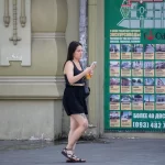 Фото тату: Девушка с татуировкой в стиле дотворк на голени, изображающей мандалу и растительные элементы.