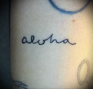 Фото татуировки надписи 'Aloha' на руке. Минималистичный дизайн, простой шрифт, популярные идеи для тату.