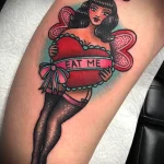 Татуировка с рисунком девушки в чулках которая держит сердце и надпись Съешь меня - tatufoto.com 10022023 - 126
