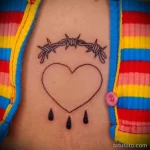 Татуировка сердце слёзы и колючая проволока между грудей девушки - tatufoto.com 10022023 - 161